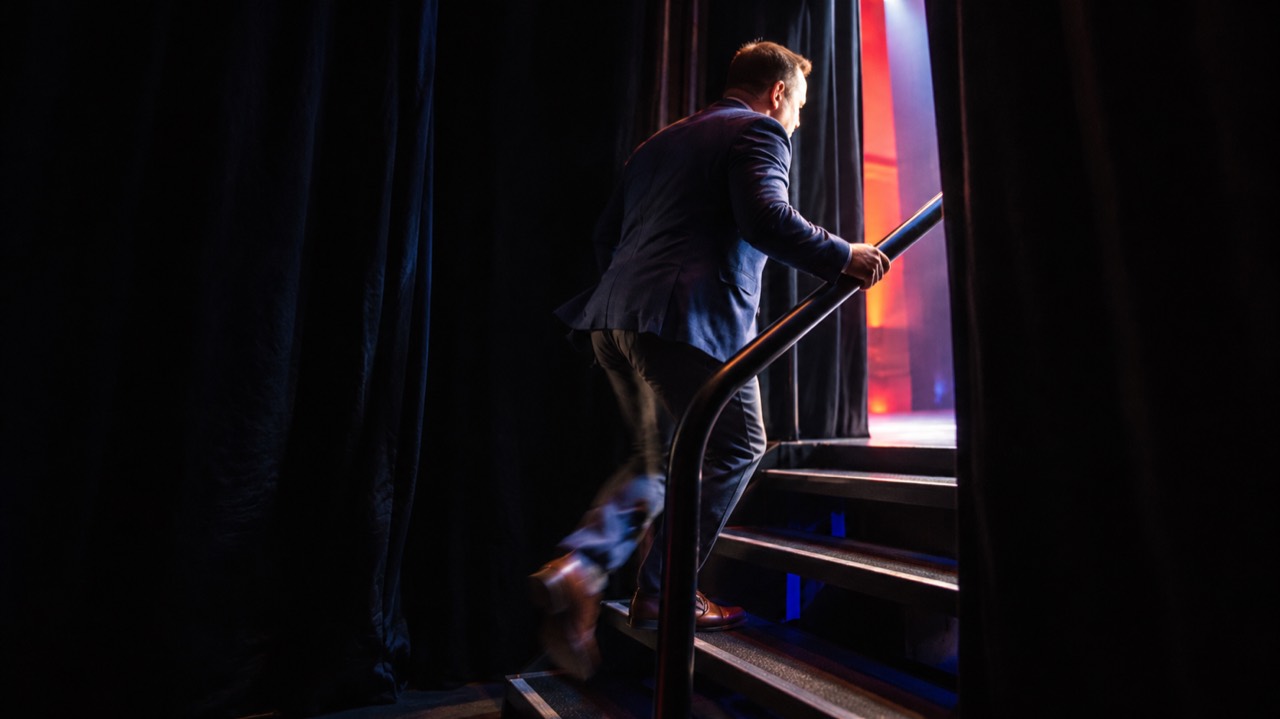 Emmet Scott walking up the backstage stairs toward the stage